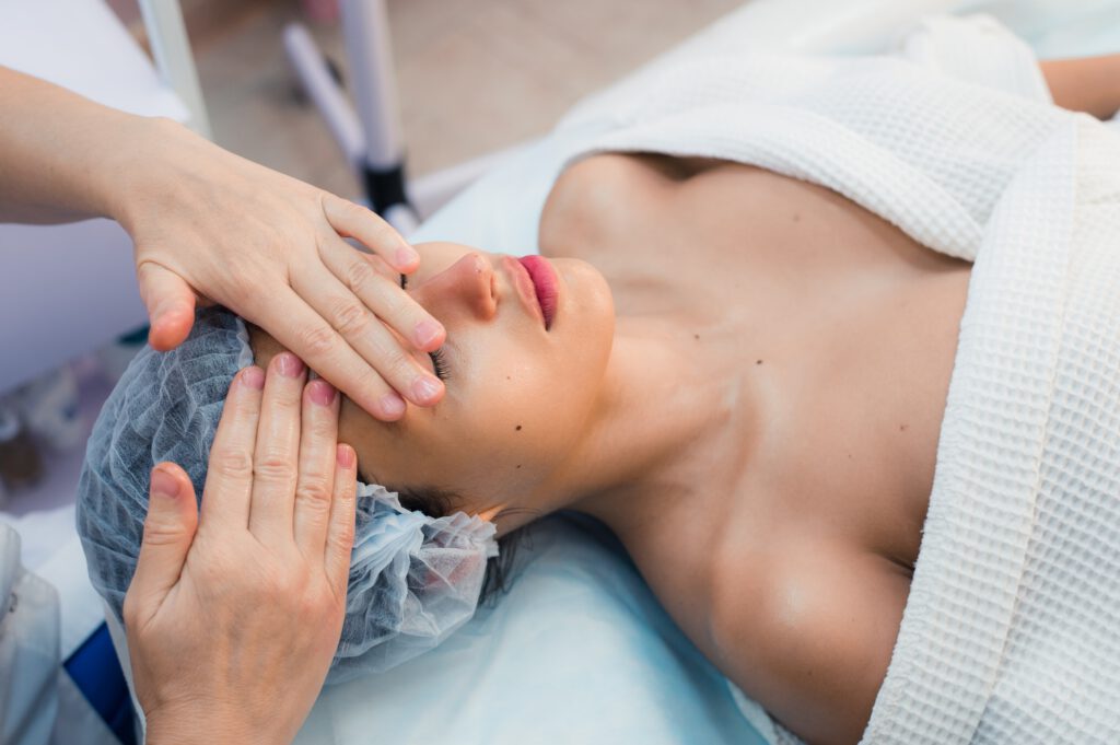 Smiling brunette enjoying a head massage in the health spa